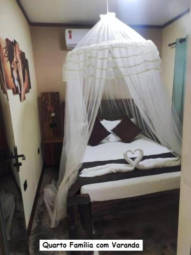 a bedroom with a bed with a mosquito net at Sanctuary Pirenópolis Suítes e Flats in Pirenópolis