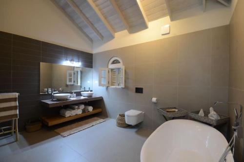 y baño con aseo, lavabo y espejo. en Luxury 4 bed villa in Mullins St Peter - Sugar Palm House, en Saint Peter