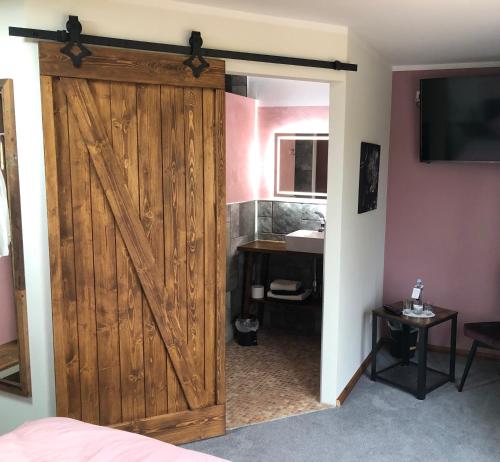 a sliding barn door in a bedroom with a sink at Brauhaisla in Konradsreuth