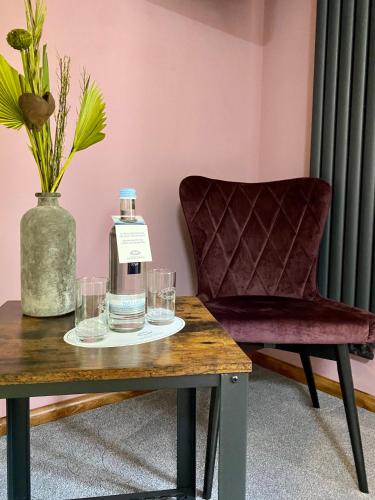 a bottle of water and glasses on a table at Brauhaisla in Konradsreuth