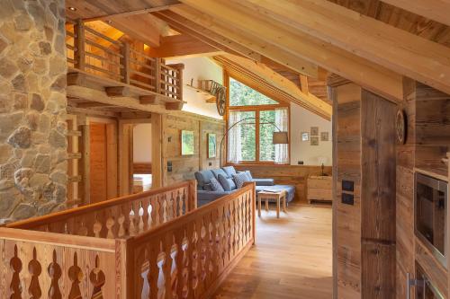 a living room with a wooden staircase in a log cabin at Chalet Mornà in San Martino in Badia