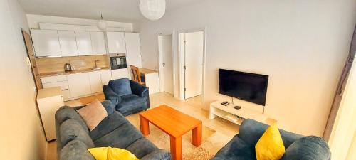 a living room with two blue couches and a table at Sunflower Apartments in Pristina