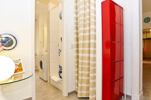 a laundry room with a red cabinet and a washing machine at Urban Art Kreuzberg in Berlin