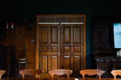 a group of wooden doors in a room with chairs at Beautiful farmhouse near Abergavenny - Sleeps 6-26 in Grosmont