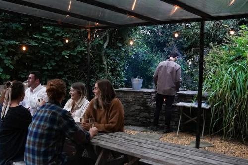 a group of people sitting at a table under a canopy at Beautiful farmhouse near Abergavenny - Sleeps 6-26 in Grosmont