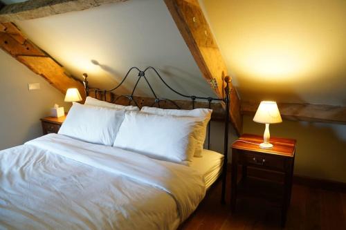 a bedroom with a white bed with two lamps on tables at Beautiful farmhouse near Abergavenny - Sleeps 6-26 in Grosmont