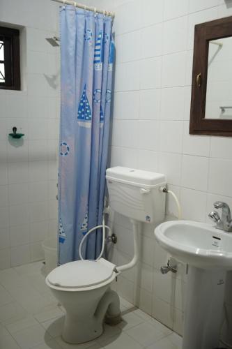 a bathroom with a toilet and a sink at Carpe DiemStay in Kushālnagar
