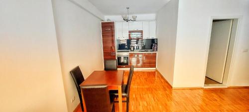 a dining room with a table and chairs and a kitchen at Sunflower Apartments in Pristina