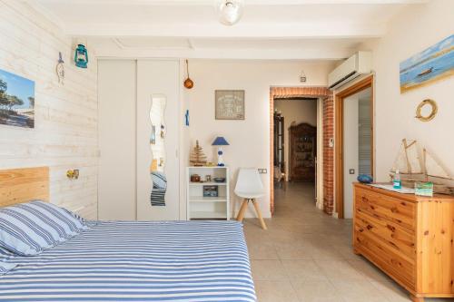 a bedroom with a blue and white bed and a hallway at Au Petit Pédegouaty in Heugas