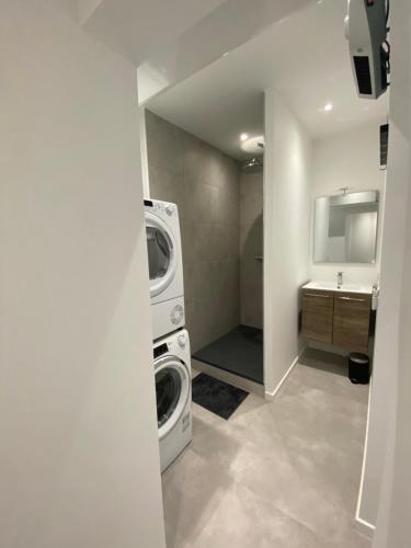 une salle de bain avec une machine à laver et un lavabo dans l'établissement La Clé - Climatisation - Wifi - Port et Gare, à Toulon