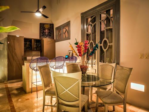 a dining room with a glass table and chairs at Casona 66 Merida Boutique Hotel in Mérida