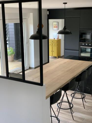 a kitchen with a wooden table and two mirrors at Ty Marie Neiz Vran - Villa luxe vue mer, 80 mètres de la plage in Kerlouan