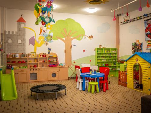 a childrens play room with a tree mural on the wall at Hunguest Hotel Gyula in Gyula