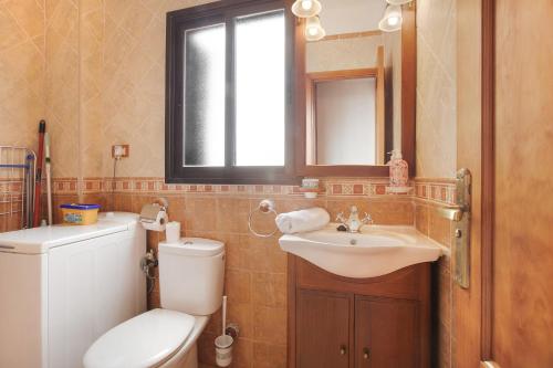uma casa de banho com um WC, um lavatório e um espelho. em Casa Nanda em Fasnia