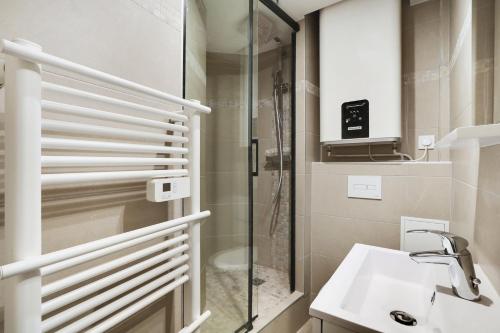 une salle de bain avec douche et lavabo dans l'établissement Pick A Flat's Apartments in Saint-Lazare - Rue de Londres, à Paris