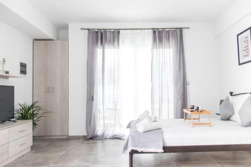 a white bedroom with a bed and a window at Spacious Flat For Friends & Couples With Balcony in Heraklio Town
