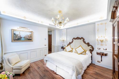 a bedroom with a bed and a chair and a chandelier at Monaco & Grand Canal in Venice