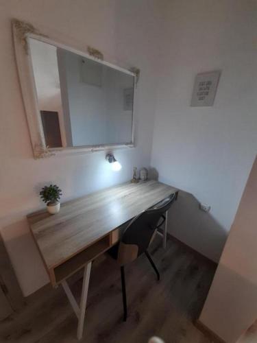 a desk in a room with a mirror and a chair at Apartman Dujmović 1 in Otočac