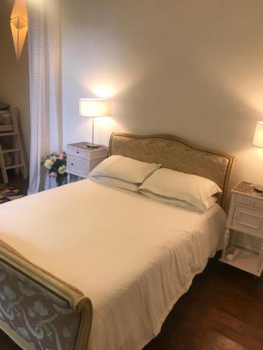 a bedroom with a large bed with white sheets at 17th Century Manor with Private Pool in Saint-Germain-les-Belles