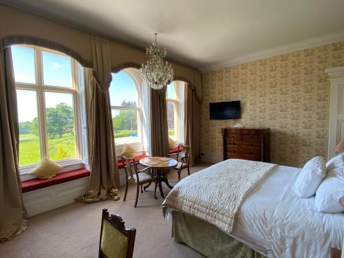 a bedroom with a bed and a table and chairs at Rossington Hall in Doncaster