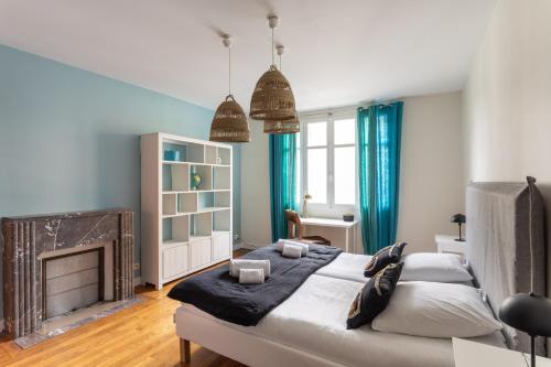 ein Schlafzimmer mit einem großen Bett und einem Kamin in der Unterkunft Le Monte Carlo - Appartement 3 chambres en centre ville in Rennes