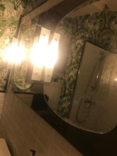 une salle de bain avec un grand miroir rond et une lumière dans l'établissement 17th Century Manor with Private Pool, à Saint-Germain-les-Belles