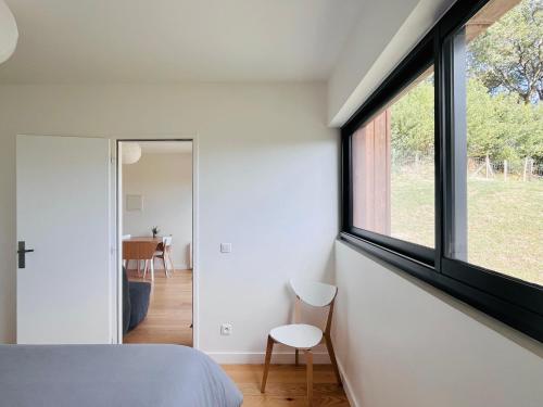 ein Schlafzimmer mit einem großen Fenster an der Wand in der Unterkunft Calme, mer et montagne Anglet in Anglet