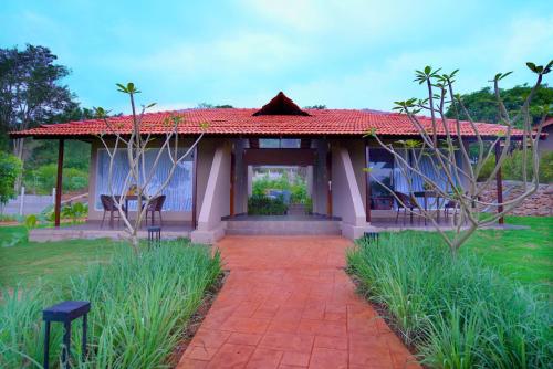 a house with a red roof and a patio at Ravishing Retreat Resort in Rāmanagaram