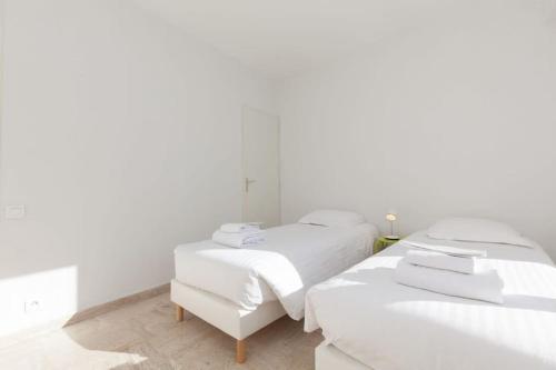 a white room with two beds and a chair at Chic and modern apt with terrace - La Croisette in Cannes