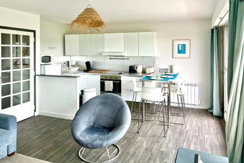 une cuisine avec une chaise bleue dans une pièce dans l'établissement Le Hygge, à Saint-Malo