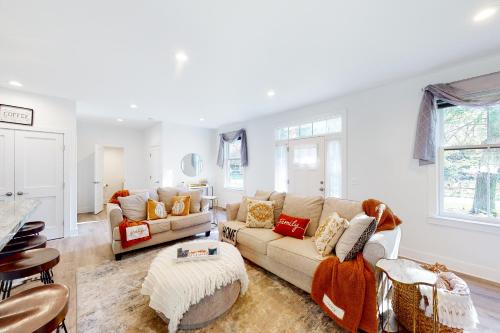 a living room with two couches and a table at Pasadena Retreat in Glen Burnie