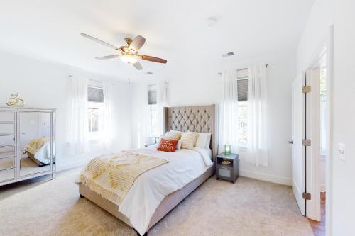a white bedroom with a bed and a ceiling fan at Pasadena Retreat in Glen Burnie