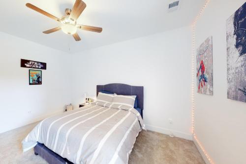 a bedroom with a bed with a ceiling fan at Pasadena Retreat in Glen Burnie
