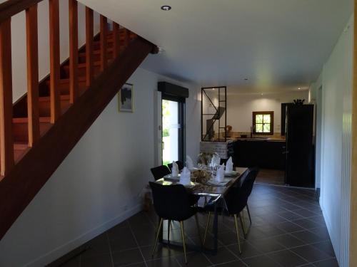 une salle à manger avec une table, des chaises et un escalier dans l'établissement Le Clos de la Déesse, à La Ferté-Saint-Cyr