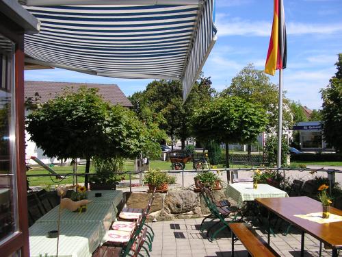 a patio with benches and a table and a flag at Pension Lindenallee in Neuendettelsau