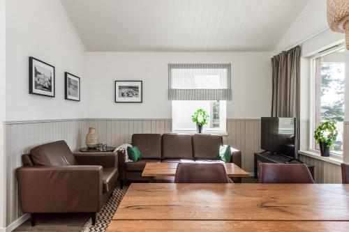 a living room with a couch and a table at Karlstad Swecamp Bomstadbaden in Karlstad