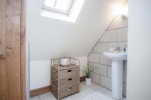 a bathroom with a sink and a toilet and a sink at The Old School Cottage Ship Farm - 1 Bedroom - Rhossili in Rhossili