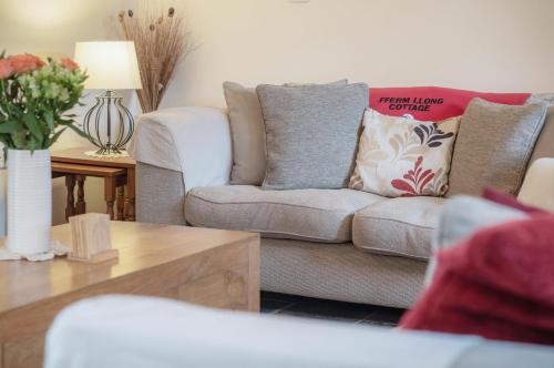 a living room with a couch and a table at Fferm-Llong Cottage Ship Farm - 2 Bedroom -Rhossili in Rhossili