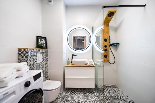 ein Badezimmer mit einem Waschbecken, einem WC und einem Spiegel in der Unterkunft Metro Targówek Cosy Apartment in Warschau