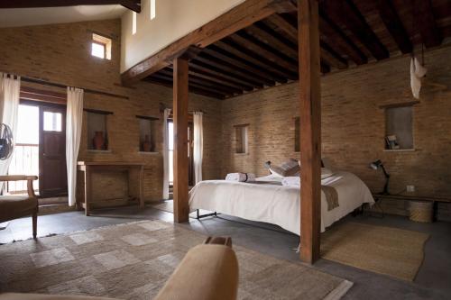 a bedroom with a bed in a room with brick walls at Traditional Homes - Swotha in Pātan