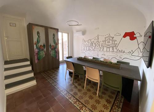 a dining room with a table and chairs and a staircase at Liotru Maisonne in Catania