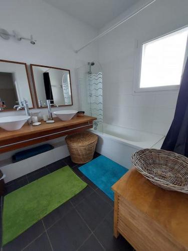 une salle de bain avec un lavabo et un miroir dans l'établissement Belle villa contemporaine, à La Teste-de-Buch