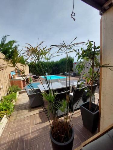 un patio avec une table et des chaises et une piscine dans l'établissement Belle villa contemporaine, à La Teste-de-Buch