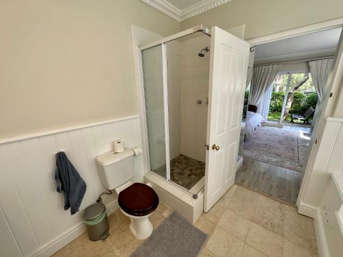 a bathroom with a toilet and a glass shower at Constantiaberg Eco-Villa in Cape Town