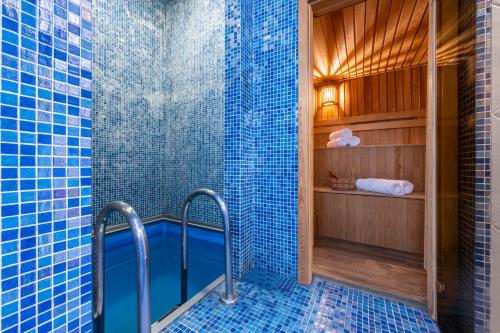 a blue tiled bathroom with a shower with blue tiles at Sairme Hotels & Resorts in Sairme