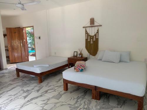 a bedroom with two beds and a chandelier at Los Arcos Hotel - TULUM in Tulum