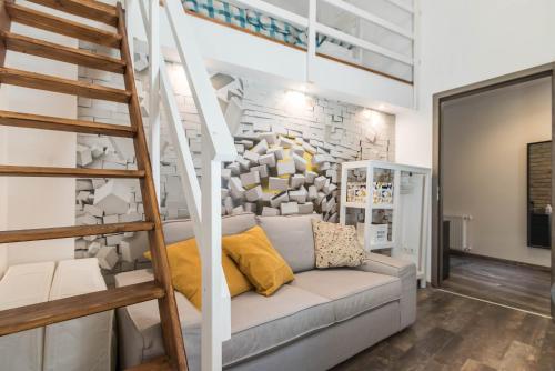 - un salon avec un canapé et un escalier dans l'établissement Katarina Apartment Blaha Square, à Budapest