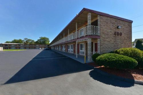 a large building with a parking lot in front of it at Economy Inn in East Hartford