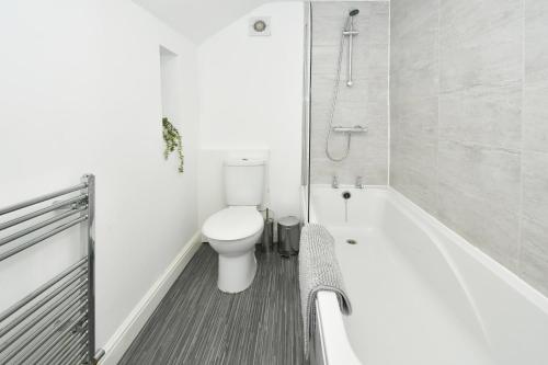 e bagno bianco con servizi igienici e vasca. di Victoria House by YourStays, City Centre, free parking, sleeps 6 a Stoke on Trent