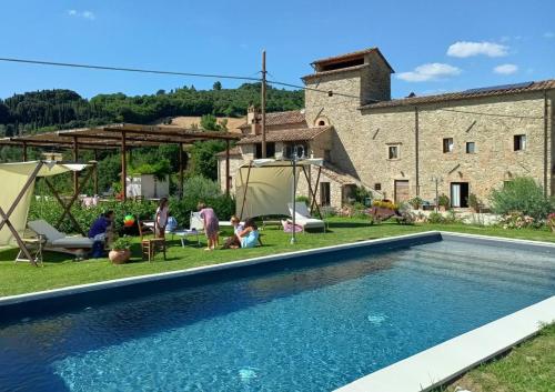 a villa with a swimming pool in front of a building at Casale Regnano in Lama